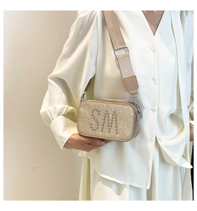 Detailed view of the champagne gold sequined crossbody bag with silver SM letter pattern
