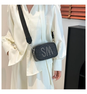 Detail of black camera bag with glitter finish, silver rivet SM logo and wide strap