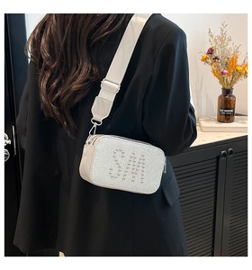 Detail of white sequin crossbody bag with silver stud SM logo and wide fabric strap