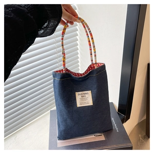 Dettaglio borsa tote in denim con fodera a quadri rossi e manici in corda intrecciata