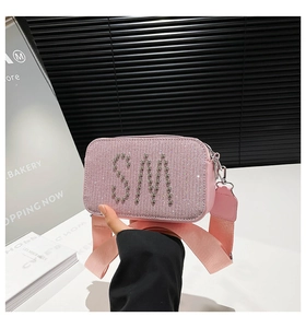 Detailed macro view of pink sequin texture and SM silver rivet decoration on camera bag