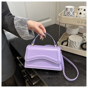 Close-up of lavender PU leather handbag with geometric wave stitching and top handle