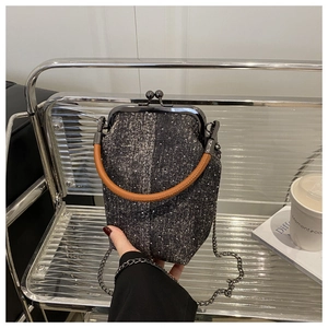 Détail du sac docteur en denim tweed avec fermoir métallique et poignée en cuir marron
