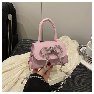 Roze mini handtas met een strass-strikje en een zilverkleurige metalen ketting