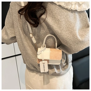 Detail view of the mini patchwork crossbody bag worn by a model in a clean indoor setting