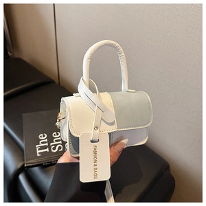 Detail view of mini white and blue patchwork PU leather handbag with gold D-ring hardware