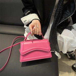 Trendy rose pink leather crossbody bag with unique wavy stitching and elegant top handle