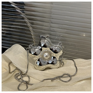 Detailed close-up of a silver flower-shaped mini bag with pearl detail and snake chain