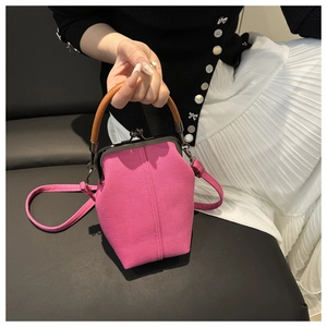 Close-up of rose pink canvas doctor bag with retro metal clip and wooden handle