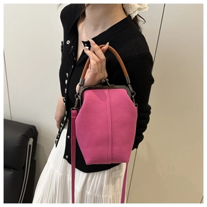 Detail of rose pink canvas crossbody bag with vintage bronze clasp and brown handle