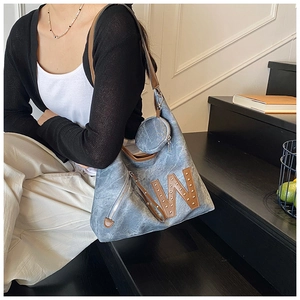 Detail view of large denim tote bag with leather W logo and round coin purse