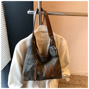 Detalle del bolso de lona con parche 'W' de cuero, remaches y monedero pequeño