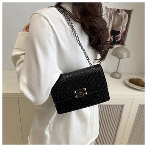 Close-up of black animal-embossed leather texture and silver chain strap on crossbody bag
