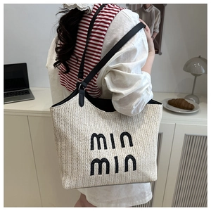 Lifestyle view of woven tote bag with contrast black straps and min min embroidery