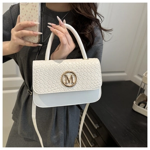 Détail du sac bandoulière blanc avec rabat tissé et logo M doré sur le devant