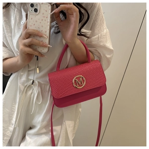 Détail du mini sac bandoulière rose fuchsia avec texture tressée et logo M doré