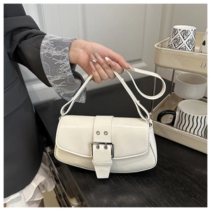 Detailed macro view of white leather baguette bag with silver buckles and fine texture