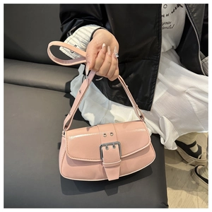 Detail of pink patent leather handbag with oversized metal buckle in Y2K style