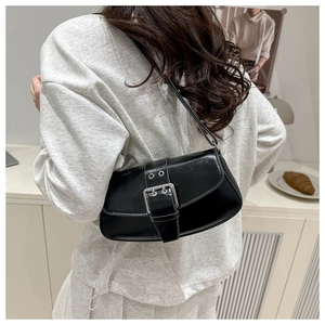 Detail showing high-gloss black leather shoulder bag with a large silver buckle finish