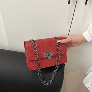 Red crossbody bag with woven texture and silver chain strap for summer street style