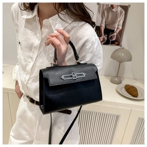 Gros plan d'un sac à main noir en cuir avec un fermoir en métal argenté minimaliste et chic