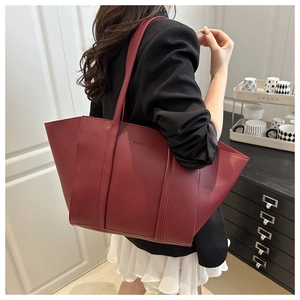 Side view of a vintage burgundy leather tote bag styled with a professional commute outfit