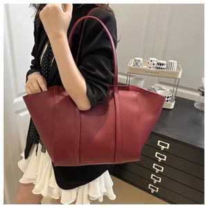 Detail of burgundy textured leather tote bag showing large capacity for office commute