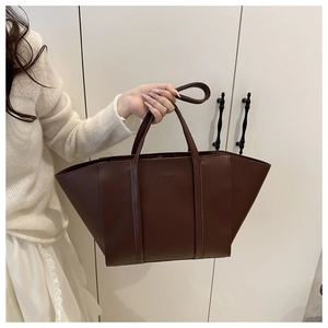 Detail of dark brown tote bag showing the embossed FASHION logo and smooth PU leather texture