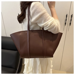 Detail of large brown PU leather tote bag with FASHION logo and long shoulder strap
