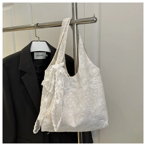 Detailed embroidery on white lace tote bag with a decorative side ribbon bow