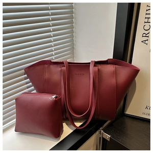 Detail view of burgundy leather bucket bag set with fashion embossed text and small pouch
