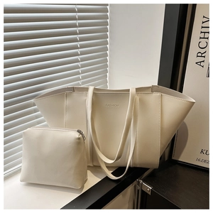Detail of cream tote bag with small pouch showing fashion embossing and soft leather texture
