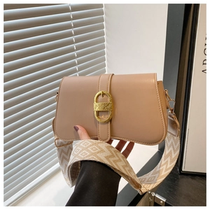 Close-up of beige leather shoulder bag with gold metal buckle and geometric woven strap