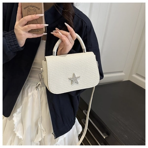 Detailansicht der beigen Kettentasche mit Diamantstern und Twill-Stoffstruktur