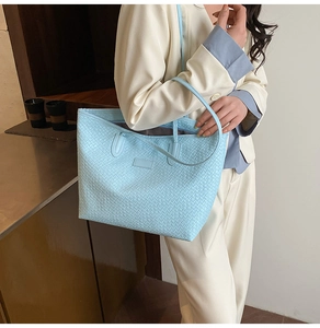 Detail of light blue woven tote bag with adjustable shoulder strap for casual wear