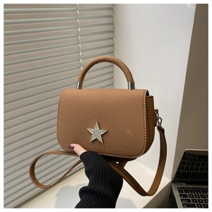 Detailed texture of brown woven chain bag with a silver glitter star emblem