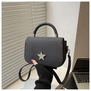 Detail einer schwarzen Web-Tasche mit glitzerndem Stern und steifem Rundgriff-Design