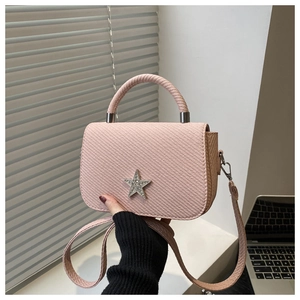 Detailed texture of pink square bag featuring diamond star ornament and top handle