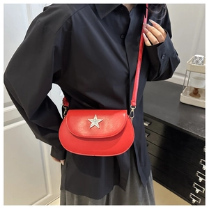 Detail of red leather saddle bag with star buckle shown on model for size and style