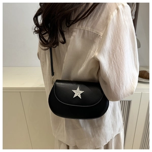 Detail shot of a black leather saddle bag with a silver rhinestone star buckle decoration
