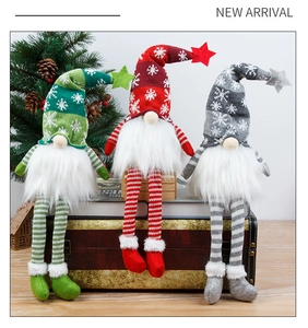 Close-up of three festive Christmas gnomes with striped long legs on vintage decor