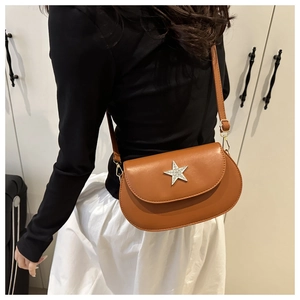 Brown matte PU leather saddle bag with star metal buckle shown on model from side angle