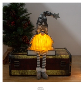 Close-up of glowing Christmas gnome with snowflake knit hat on vintage suitcase