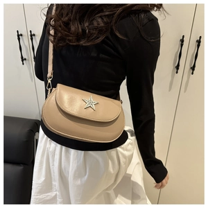 Adjustable beige star buckle saddle bag shown on model with chic summer outfit