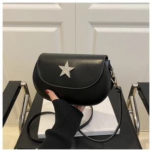 Detail of black saddle bag featuring a rhinestone-embellished silver star buckle and strap