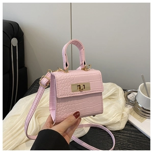 Detail of light pink crocodile pattern mini bag with golden lock and adjustable strap