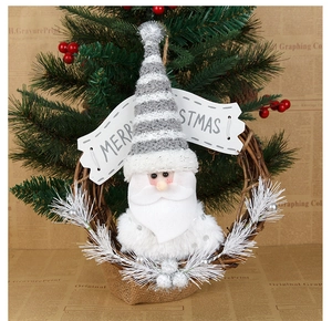 Close-up of Merry Christmas wooden sign and Santa figure on rustic vine wreath