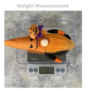 Gnome d'Halloween avec chapeau de citrouille sur balance pesant 81,7 grammes