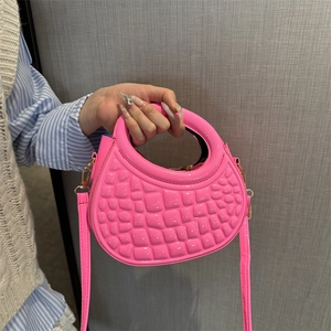 Pink semi-circle embossed patent leather handbag with a top handle and shoulder strap