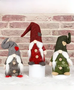 Drei bunte Weihnachtswichtel mit langen Mützen und Holzknöpfen als Festtagsdekoration